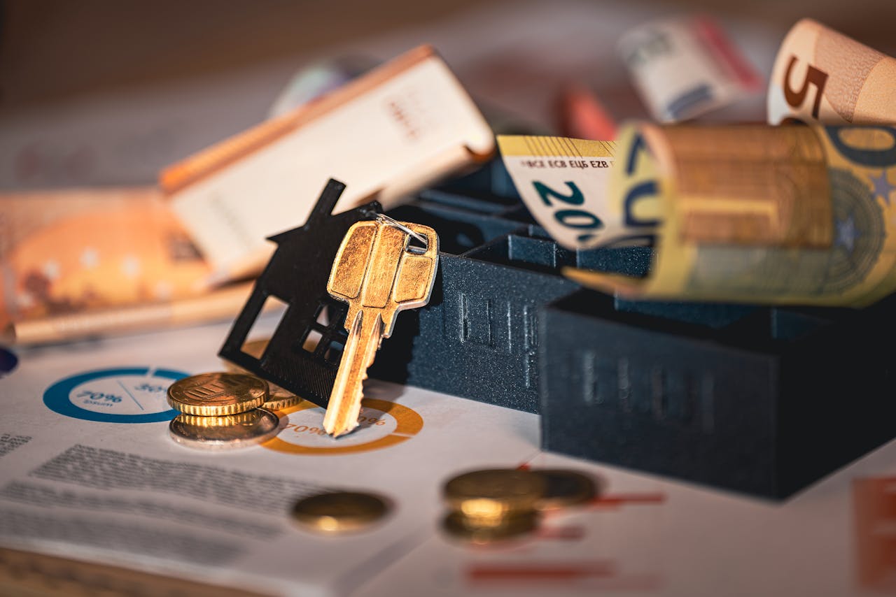 services-01 Close-up of house keys, euro bills, and charts symbolizing real estate investment and finance.