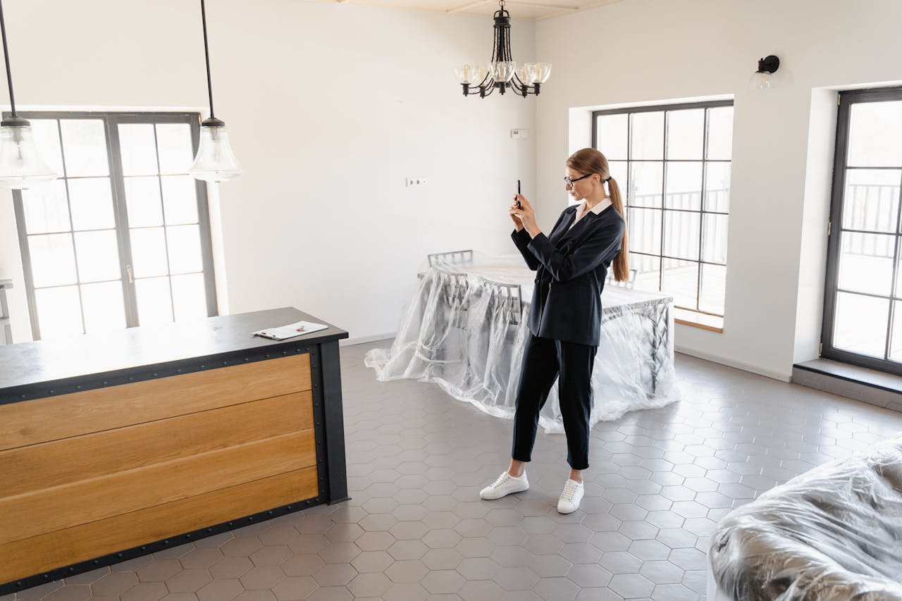 services-02 A real estate agent taking pictures of a modern, empty house interior.
