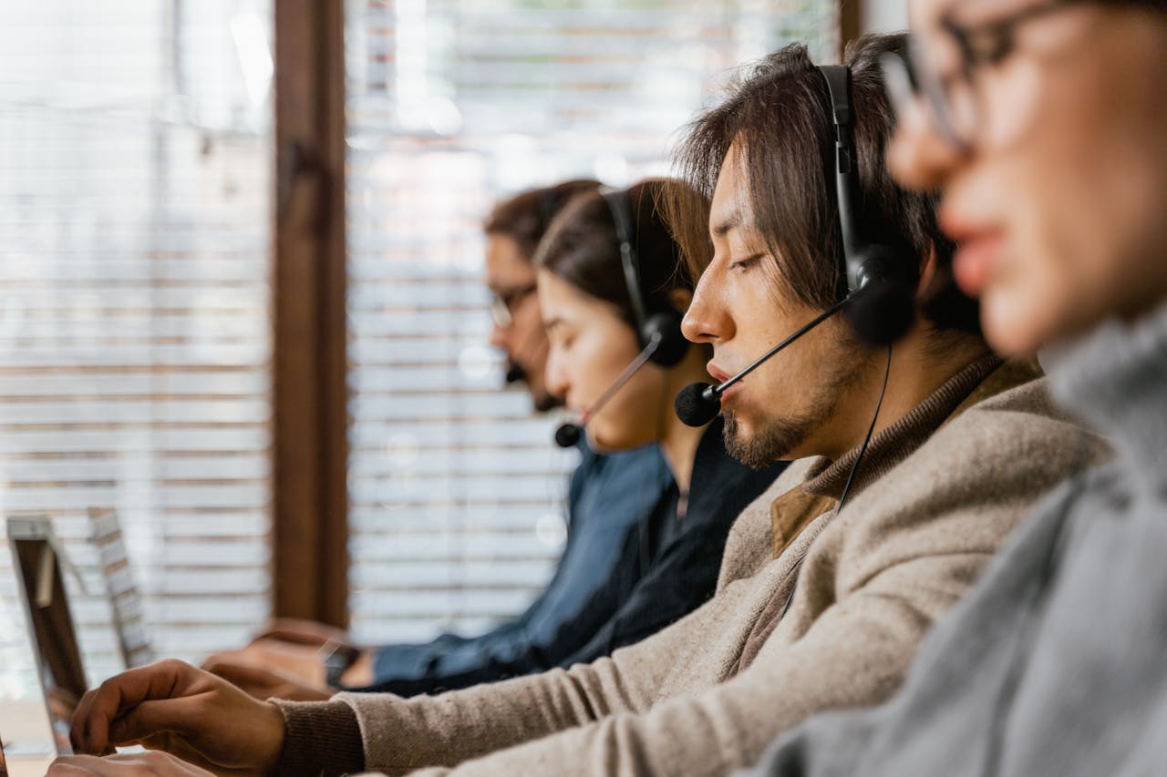 why-choose-us Call center employees working diligently with headsets, offering dedicated customer service.